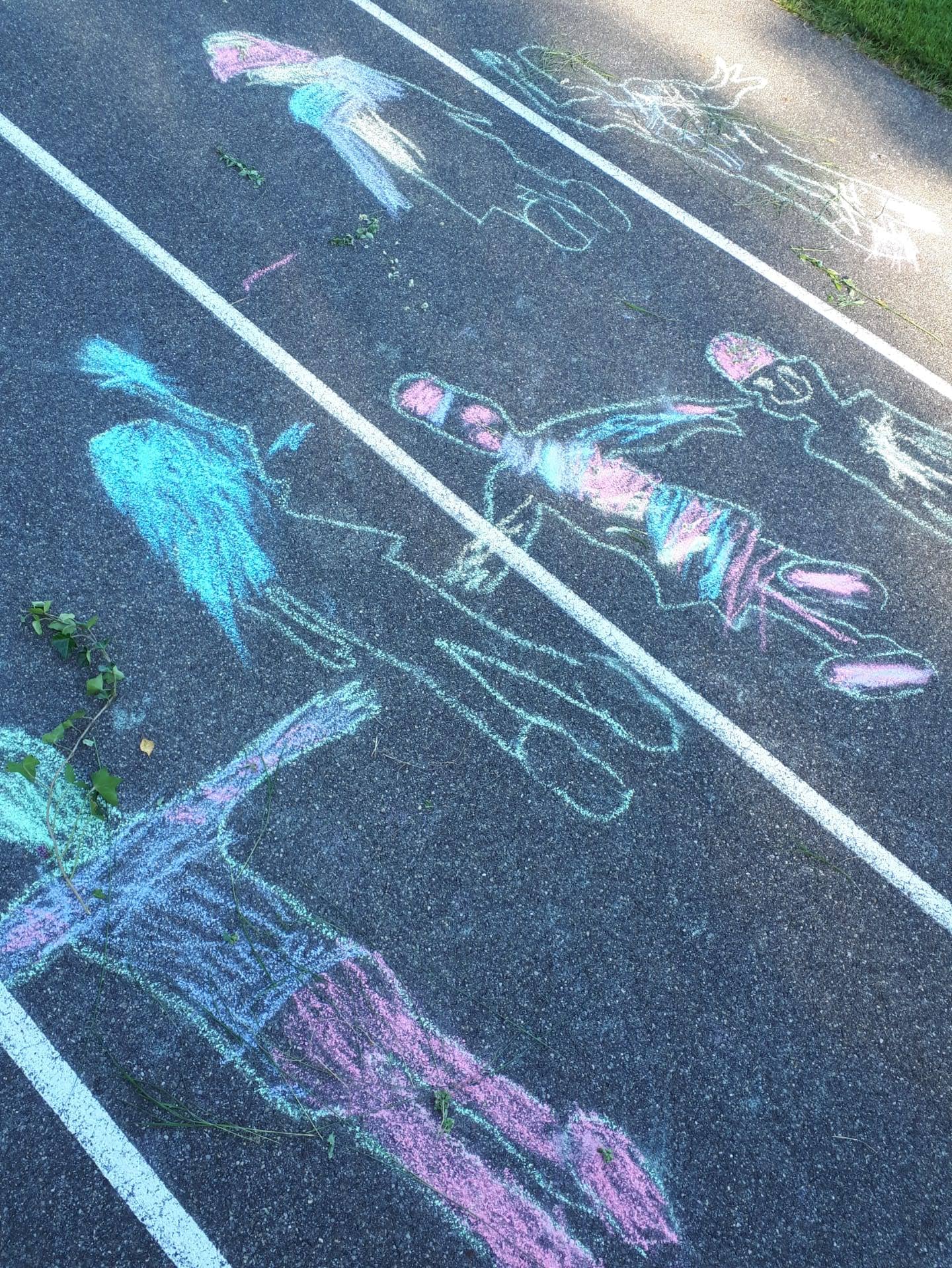 Lasten värikkäillä katuliiduilla asfalttiin piirtämiä omakuvia